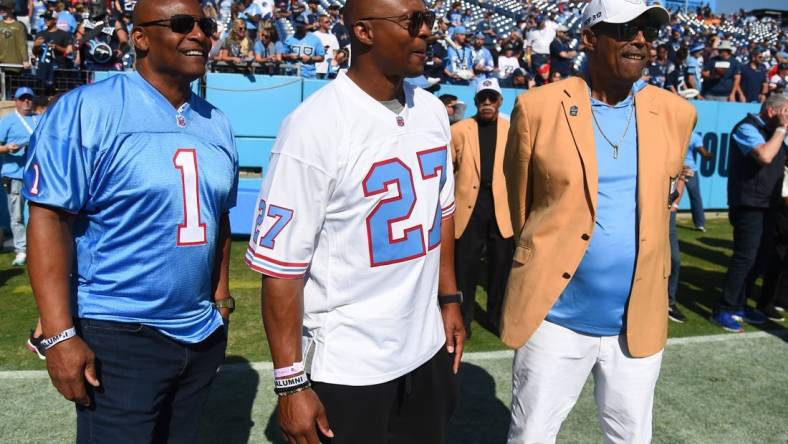 Oct 23, 2022; Nashville, Tennessee, USA; Former Houston Oilers quarterback Warren Moon (1), Tennessee Titans running back Eddie George (27) and NFL Hall of Famer Robert Brazile watch warmups before the game against the Indianapolis Colts at Nissan Stadium. Mandatory Credit: Christopher Hanewinckel-USA TODAY Sports