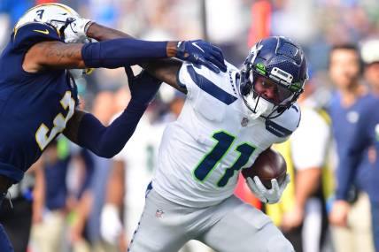 Oct 23, 2022; Inglewood, California, USA; Seattle Seahawks wide receiver Marquise Goodwin (11) runs the ball against Los Angeles Chargers safety Derwin James Jr. (3) during the first half at SoFi Stadium. Mandatory Credit: Gary A. Vasquez-USA TODAY Sports