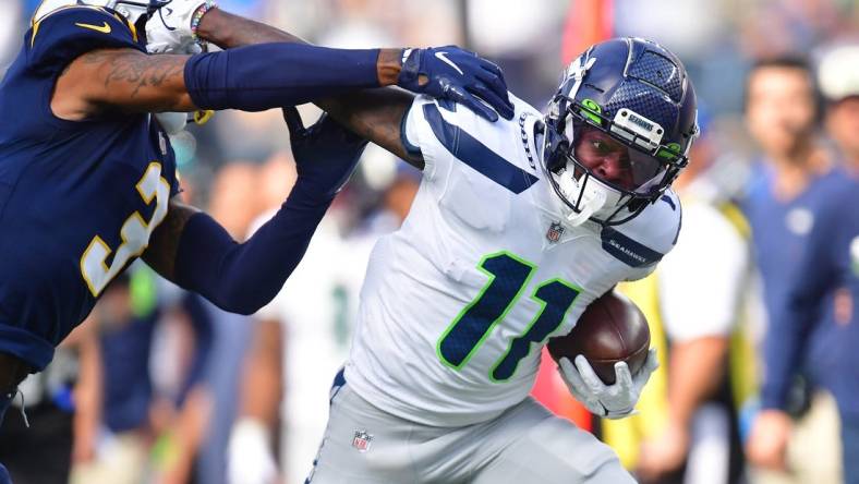 Oct 23, 2022; Inglewood, California, USA; Seattle Seahawks wide receiver Marquise Goodwin (11) runs the ball against Los Angeles Chargers safety Derwin James Jr. (3) during the first half at SoFi Stadium. Mandatory Credit: Gary A. Vasquez-USA TODAY Sports