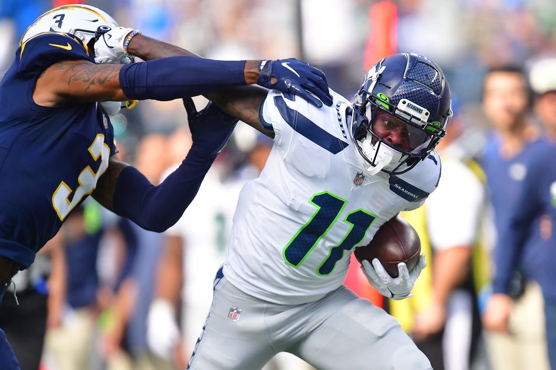 Oct 23, 2022; Inglewood, California, USA; Seattle Seahawks wide receiver Marquise Goodwin (11) runs the ball against Los Angeles Chargers safety Derwin James Jr. (3) during the first half at SoFi Stadium. Mandatory Credit: Gary A. Vasquez-USA TODAY Sports