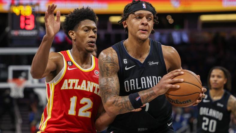 Dec 14, 2022; Orlando, Florida, USA;  Atlanta Hawks forward De'Andre Hunter (12) guards Orlando Magic forward Paolo Banchero (5) in the fourth quarter at Amway Center. Mandatory Credit: Nathan Ray Seebeck-USA TODAY Sports