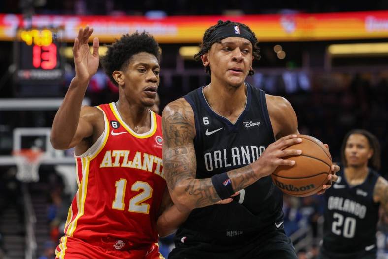 Dec 14, 2022; Orlando, Florida, USA;  Atlanta Hawks forward De'Andre Hunter (12) guards Orlando Magic forward Paolo Banchero (5) in the fourth quarter at Amway Center. Mandatory Credit: Nathan Ray Seebeck-USA TODAY Sports