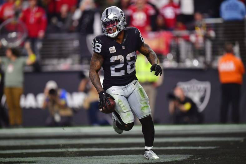 January 1, 2023; Paradise, Nevada, USA; Las Vegas Raiders running back Josh Jacobs (28) scores a touchdown against the San Francisco 49ers during the second half at Allegiant Stadium. Mandatory Credit: Gary A. Vasquez-USA TODAY Sports