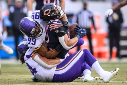 Jan 8, 2023; Chicago, Illinois, USA; Chicago Bears running back David Montgomery (32) runs the ball and is tackled by Minnesota Vikings inside linebacker Eric Kendricks (54) and outside linebacker Danielle Hunter (99) during the first quarter at Soldier Field. Mandatory Credit: Daniel Bartel-USA TODAY Sports