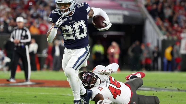 Jan 16, 2023; Tampa, Florida, USA; Dallas Cowboys running back Tony Pollard (20) breaks the tackle of Tampa Bay Buccaneers linebacker Devin White (45) in the first half during the wild card game at Raymond James Stadium. Mandatory Credit: Kim Klement-USA TODAY Sports