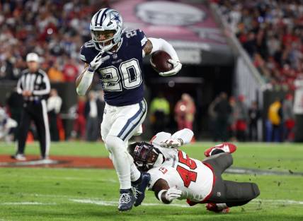 Jan 16, 2023; Tampa, Florida, USA; Dallas Cowboys running back Tony Pollard (20) breaks the tackle of Tampa Bay Buccaneers linebacker Devin White (45) in the first half during the wild card game at Raymond James Stadium. Mandatory Credit: Kim Klement-USA TODAY Sports