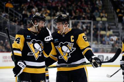 Jan 13, 2023; Pittsburgh, Pennsylvania, USA;  Pittsburgh Penguins defenseman Ty Smith (24) and center Sidney Crosby (87) talk on the ice against the Winnipeg Jets during the third period at PPG Paints Arena. Mandatory Credit: Charles LeClaire-USA TODAY Sports