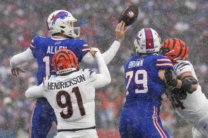 Jan 22, 2023; Orchard Park, New York, USA; Buffalo Bills quarterback Josh Allen (17) throws the ball away as he is tackled by Cincinnati Bengals defensive end Trey Hendrickson (91) in the first quarter of the NFL divisional playoff football game between the Cincinnati Bengals and the Buffalo Bills during an AFC divisional round game at Highmark Stadium. Mandatory Credit: Sam Greene-USA TODAY Sports