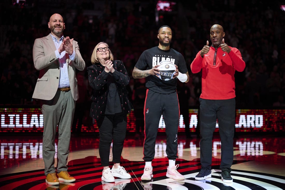 Portland Trail Blazers GM Joe Cronin, left, owner Jody Allen, and head coach Chauncey Billups stand with guard Damian Lillard (0) as he is congratulated on making the NBA All Star team before a game against the Washington Wizards at Moda Center. Mandatory Credit: Troy Wayrynen-USA TODAY Sports