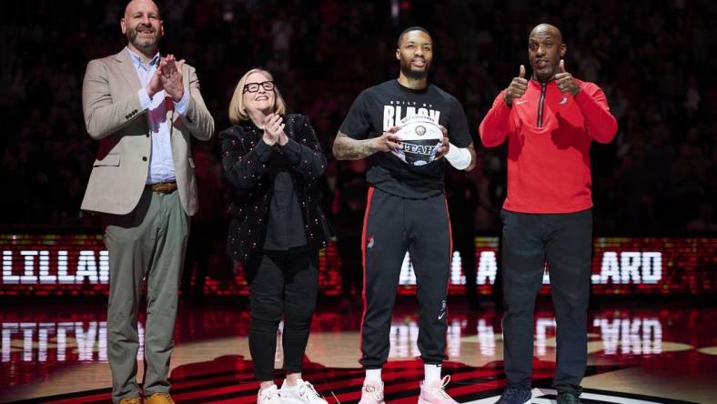 Portland Trail Blazers GM Joe Cronin, left, owner Jody Allen, and head coach Chauncey Billups stand with guard Damian Lillard (0) as he is congratulated on making the NBA All Star team before a game against the Washington Wizards at Moda Center. Mandatory Credit: Troy Wayrynen-USA TODAY Sports