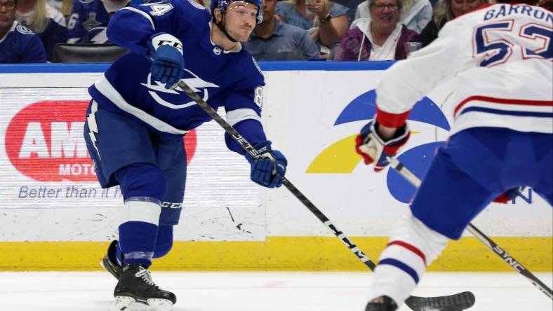 Mar 18, 2023; Tampa, Florida, USA;Tampa Bay Lightning left wing Tanner Jeannot (84) passes the puck as Montreal Canadiens defenseman Justin Barron (52) defends during the first period at Amalie Arena. Mandatory Credit: Kim Klement-USA TODAY Sports