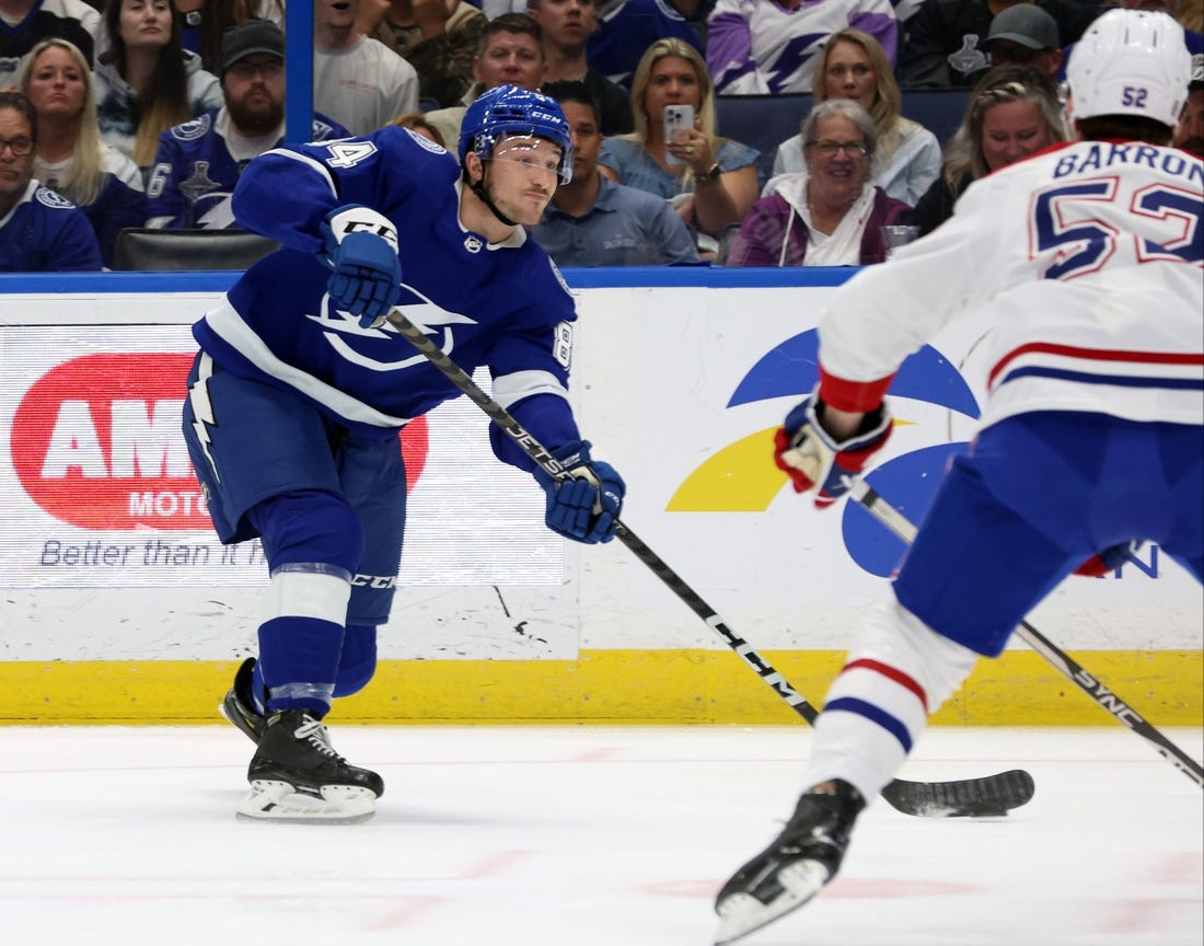 Mar 18, 2023; Tampa, Florida, USA;Tampa Bay Lightning left wing Tanner Jeannot (84) passes the puck as Montreal Canadiens defenseman Justin Barron (52) defends during the first period at Amalie Arena. Mandatory Credit: Kim Klement-USA TODAY Sports