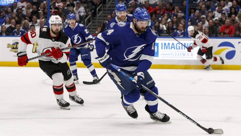 Mar 19, 2023; Tampa, Florida, USA; Tampa Bay Lightning left wing Pat Maroon (14) carries puck past New Jersey Devils left wing Tomas Tatar (90) during the second period at Amalie Arena. Mandatory Credit: Morgan Tencza-USA TODAY Sports