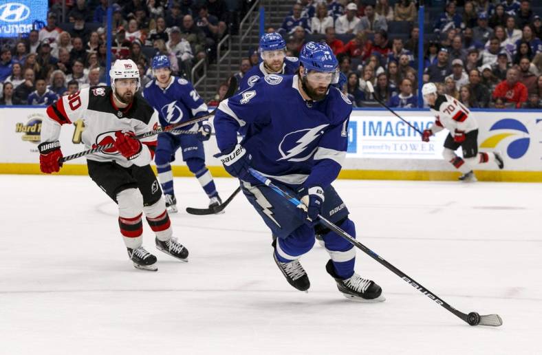 Mar 19, 2023; Tampa, Florida, USA; Tampa Bay Lightning left wing Pat Maroon (14) carries puck past New Jersey Devils left wing Tomas Tatar (90) during the second period at Amalie Arena. Mandatory Credit: Morgan Tencza-USA TODAY Sports