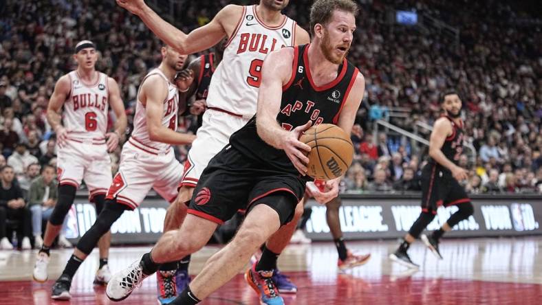 Apr 12, 2023; Toronto, Ontario, CAN; Toronto Raptors center Jakob Poeltl (19) recovers a loose ball against Chicago Bulls center Nikola Vucevic (9) during the second half of a NBA Play-In game at Scotiabank Arena. Mandatory Credit: John E. Sokolowski-USA TODAY Sports