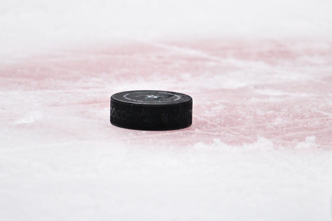 Apr 17, 2023; Dallas, Texas, USA; A view of a NHL hockey puck and the red face-off circle during the game between the Dallas Stars and the Minnesota Wild in game one of the first round of the 2023 Stanley Cup Playoffs at the American Airlines Center. Mandatory Credit: Jerome Miron-USA TODAY Sports