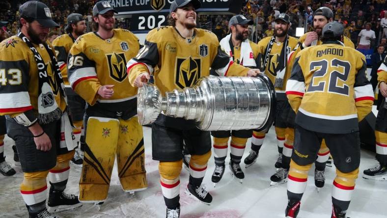 Jun 13, 2023; Las Vegas, Nevada, USA; Vegas Golden Knights forward Brett Howden (21) hoists the Stanley Cup after defeating the Florida Panthers in game five of the 2023 Stanley Cup Final at T-Mobile Arena. Mandatory Credit: Stephen R. Sylvanie-USA TODAY Sports