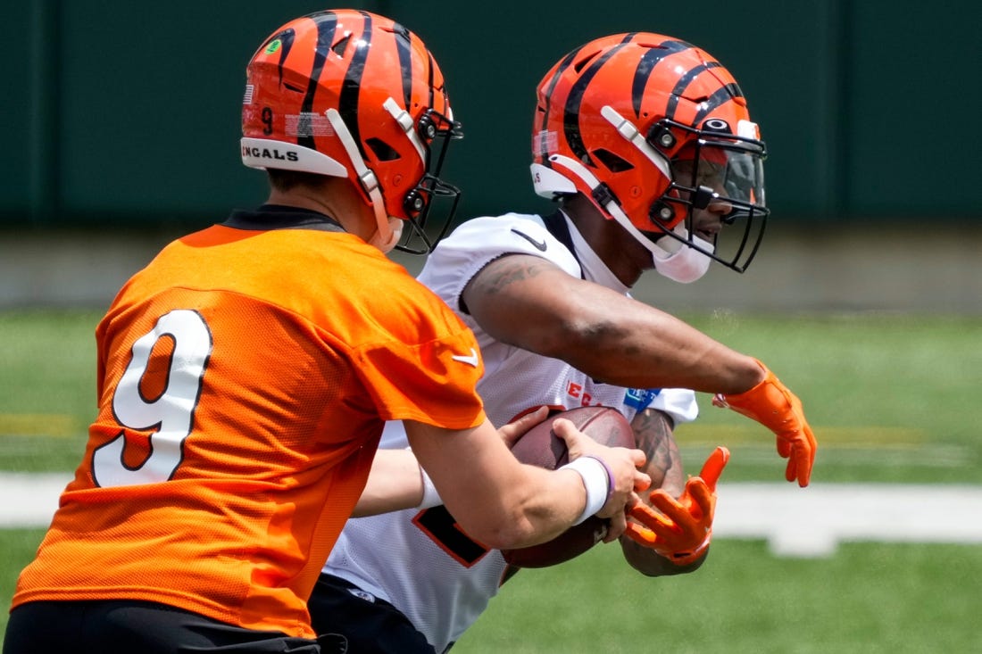 Cincinnati Bengals quarterback Joe Burrow (9) hands off to running back Joe Mixon (28) during an off-season workout inside Paycor Stadium in downtown Cincinnati on Wednesday, June 14, 2023.