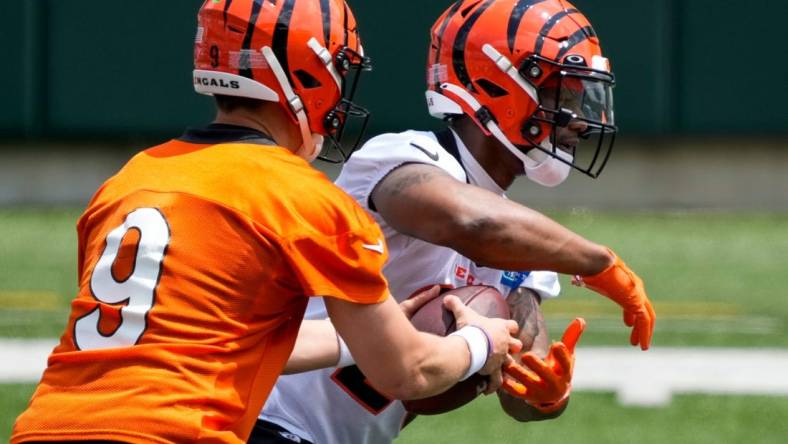 Cincinnati Bengals quarterback Joe Burrow (9) hands off to running back Joe Mixon (28) during an off-season workout inside Paycor Stadium in downtown Cincinnati on Wednesday, June 14, 2023.