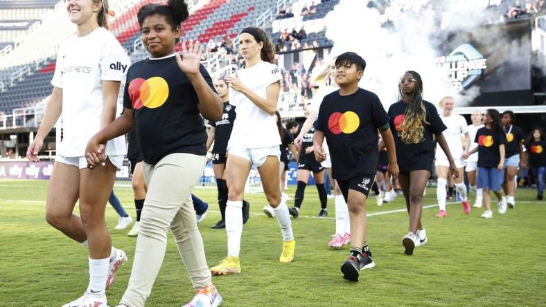 Jun 14, 2023; Washington, D.C., USA; Young fans walk with the North Carolina Courage  before ether match against the Washington Spirit at Audi Field. Mandatory Credit: Amber Searls-USA TODAY Sports