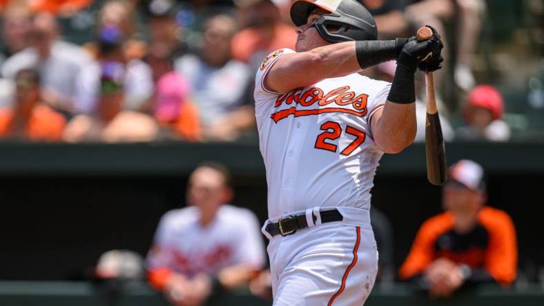 Jun 15, 2023; Baltimore, Maryland, USA; Baltimore Orioles catcher James McCann (27) hits a single during the fifth inning against the Toronto Blue Jays at Oriole Park at Camden Yards. Mandatory Credit: Reggie Hildred-USA TODAY Sports