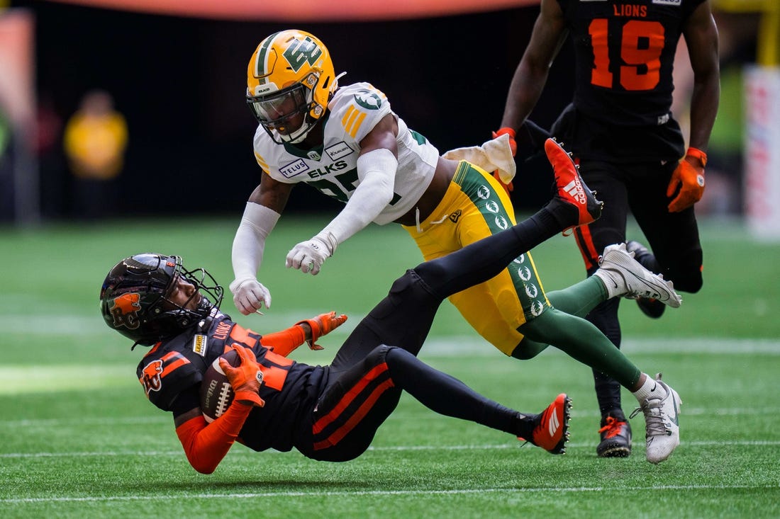 Jun 17, 2023; Vancouver, British Columbia, CAN; Edmonton Elks defensive back Dwayne Thompson II (37) tackles BC Lions receiver Alexander Hollins (13) in the first half in at BC Place. Mandatory Credit: Bob Frid-USA TODAY Sports