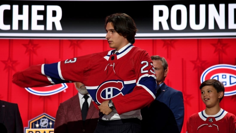 Jun 28, 2023; Nashville, Tennessee, USA; Montreal Canadiens draft pick David Reinbacher puts on his sweater after being selected with the fifth pick in round one of the 2023 NHL Draft at Bridgestone Arena. Mandatory Credit: Christopher Hanewinckel-USA TODAY Sports