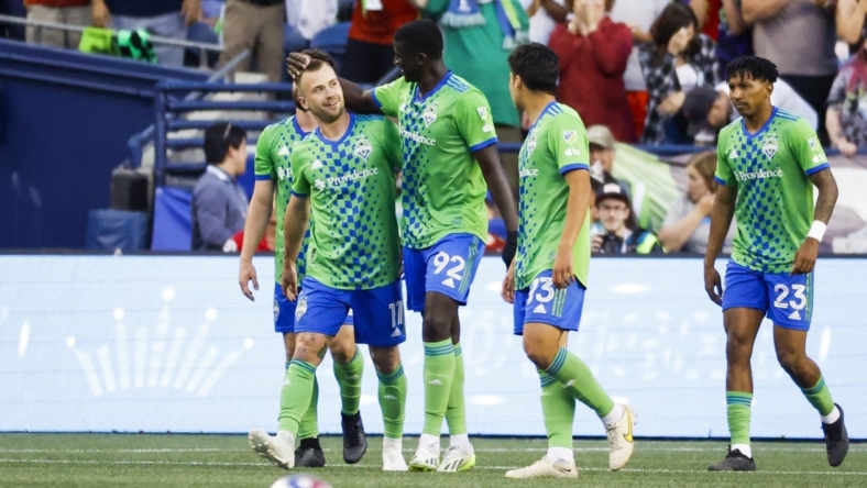 Jul 1, 2023; Seattle, Washington, USA; Seattle Sounders FC midfielder Albert Rusnak (11) celebrates with midfielder defender Abdoulaye Cissoko (92) after scoring a goal against the Houston Dynamo during the second half at Lumen Field. Seattle Sounders FC midfielder Leo Chu (23), right, walking back to midfield, assisted on the goal. Mandatory Credit: Joe Nicholson-USA TODAY Sports