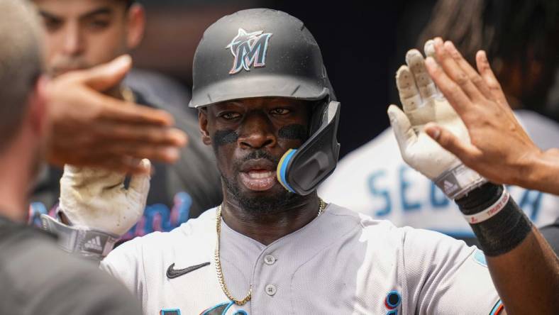 Jul 2, 2023; Cumberland, Georgia, USA; Miami Marlins center fielder Jonathan Davis (49) gets high fives after scoring a run against the Atlanta Braves during the second inning at Truist Park. Mandatory Credit: Dale Zanine-USA TODAY Sports