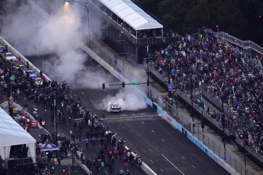 Jul 2, 2023; Chicago, Illinois, USA; NASCAR Cup Series driver Shane Van Gisbergen (91) does a burn out after winning the Grant Park 220 of the Chicago Street Race viewed from the NEMA Chicago buliding. Mandatory Credit: Jon Durr-USA TODAY Sports