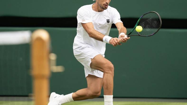 Jul 3, 2023; London, United Kingdom;  Pedro Cachin (ARG) returns the ball during his match against Novak Djokovic (SRB) on day one of the Wimbledon championships at the All England Lawn Tennis and Croquet Club. Mandatory Credit: Susan Mullane-USA TODAY Sports