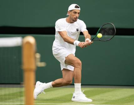Jul 3, 2023; London, United Kingdom;  Pedro Cachin (ARG) returns the ball during his match against Novak Djokovic (SRB) on day one of the Wimbledon championships at the All England Lawn Tennis and Croquet Club. Mandatory Credit: Susan Mullane-USA TODAY Sports
