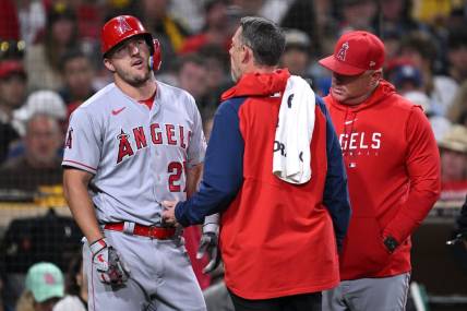 Jul 3, 2023; San Diego, California, USA; Los Angeles Angels center fielder Mike Trout (27) is checked by a trainer after an injury sustained during an at-bat in the eighth inning against the San Diego Padres at Petco Park. Mandatory Credit: Orlando Ramirez-USA TODAY Sports