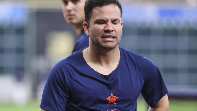 Jul 4, 2023; Houston, Texas, USA; Houston Astros designated hitter Jose Altuve (27) holds his side with an apparent injury while walking off the field during practice before the game against the Colorado Rockies at Minute Maid Park. Mandatory Credit: Troy Taormina-USA TODAY Sports