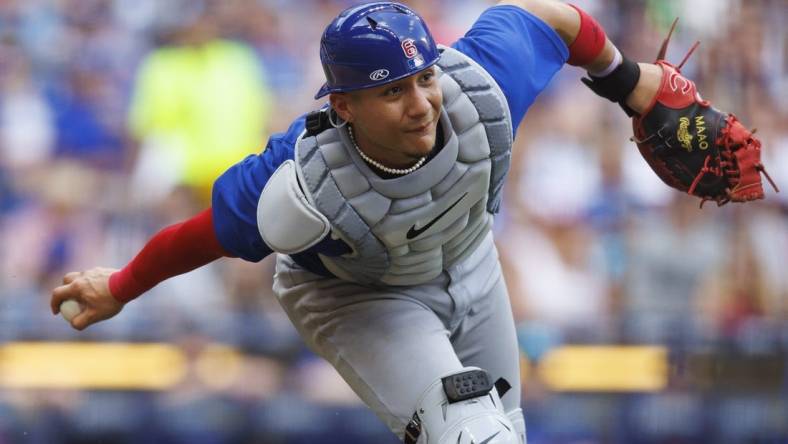 Jul 4, 2023; Milwaukee, Wisconsin, USA;  Chicago Cubs catcher Miguel Amaya (6) underhands the ball towards first base  during the sixth inning against the Milwaukee Brewers at American Family Field. Mandatory Credit: Jeff Hanisch-USA TODAY Sports