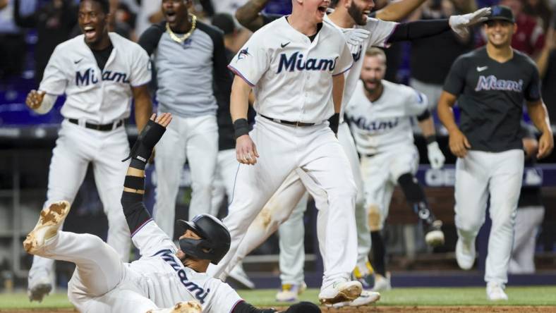 Jul 5, 2023; Miami, Florida, USA; Miami Marlins first baseman Yuli Gurriel (10) scores the winning run against the St. Louis Cardinals as Miami Marlins players celebrate during the ninth inning at loanDepot Park. Mandatory Credit: Sam Navarro-USA TODAY Sports