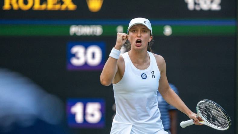 Jul 7, 2023; London, United Kingdom; Iga Swiatek (POL) reacts to a point during her match against Petra Martic (CRO) on day five of Wimbledon at the All England Lawn Tennis and Croquet Club.  Mandatory Credit: Susan Mullane-USA TODAY Sports