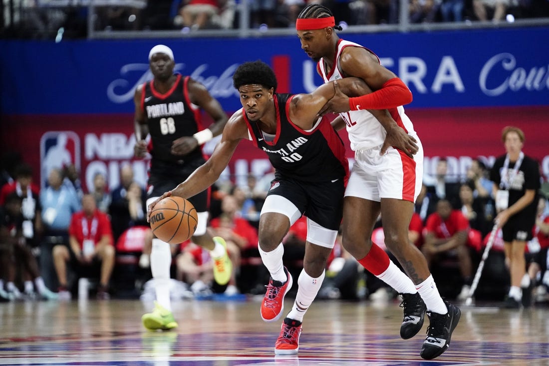 Jul 7, 2023; Las Vegas, NV, USA;  Portland Trail Blazers guard Scoot Henderson (00) dribbles the ball against Houston Rockets guard/forward Nate Hinton (62) during the first half at Thomas & Mack Center. Mandatory Credit: Lucas Peltier-USA TODAY Sports