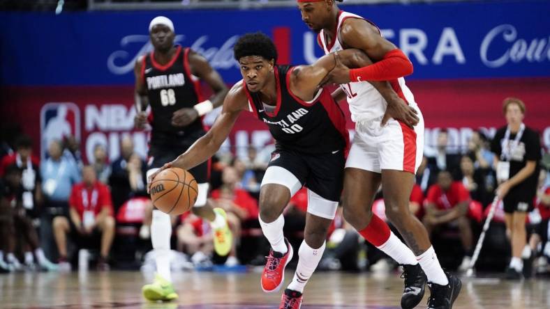 Jul 7, 2023; Las Vegas, NV, USA;  Portland Trail Blazers guard Scoot Henderson (00) dribbles the ball against Houston Rockets guard/forward Nate Hinton (62) during the first half at Thomas & Mack Center. Mandatory Credit: Lucas Peltier-USA TODAY Sports