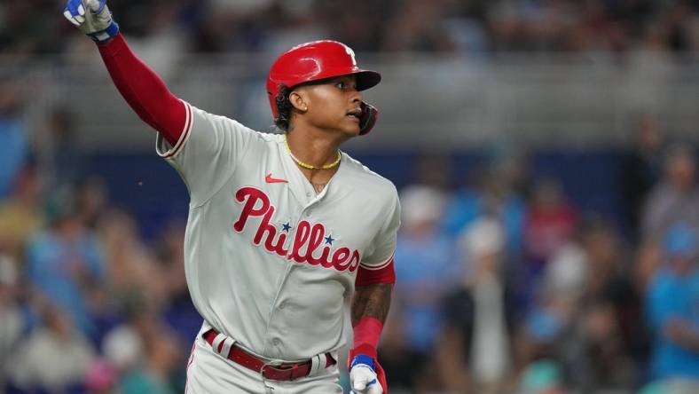 Jul 7, 2023; Miami, Florida, USA; Philadelphia Phillies left fielder Cristian Pache (19) watches his two-run home run clear the wall in the ninth inning against the Miami Marlins at loanDepot Park. Mandatory Credit: Jim Rassol-USA TODAY Sports