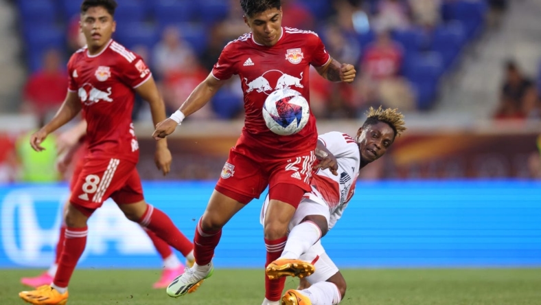 Jul 8, 2023; Harrison, New Jersey, USA; New York Red Bulls midfielder Omir Fernandez (21) battles for the ball against New England Revolution forward Latif Blessing (19) during the first half at Red Bull Arena. Mandatory Credit: Vincent Carchietta-USA TODAY Sports