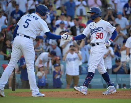 Jul 8, 2023; Los Angeles, California, USA; Los Angeles Dodgers first baseman Freddie Freeman (5) congratulates right fielder Mookie Betts (50) rounds third after hitting a lead off solo home run in the first inning at Dodger Stadium. Mandatory Credit: Jayne Kamin-Oncea-USA TODAY Sports