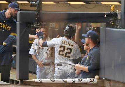 Jul 9, 2023; Milwaukee, Wisconsin, USA; Milwaukee Brewers left fielder Christian Yelich (22) celebrates in the dugout after scoring a run against the Cincinnati Reds in the first inning at American Family Field. Mandatory Credit: Michael McLoone-USA TODAY Sports