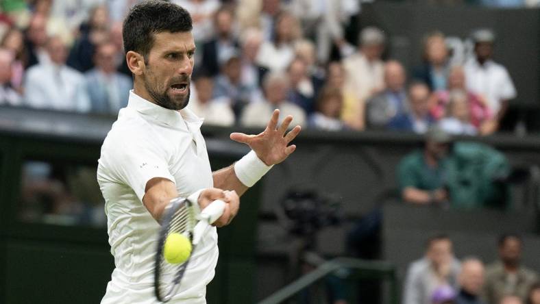 Jul 14, 2023; London, United Kingdom; Novak Djokovic (SRB) returns a shot during his match against Jannik Sinner (ITA) on day 12 at the All England Lawn Tennis and Croquet Club.  Mandatory Credit: Susan Mullane-USA TODAY Sports