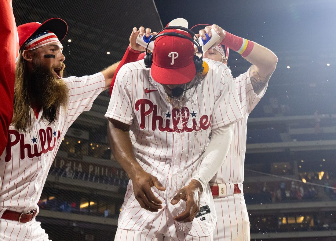 Jul 15, 2023; Philadelphia, Pennsylvania, USA; Philadelphia Phillies outfielder Johan Rojas (18) has water dumped on him by center fielder Brandon Marsh (16) and second baseman Bryson Stott (5) after a victory against the San Diego Padres at Citizens Bank Park. Mandatory Credit: Bill Streicher-USA TODAY Sports