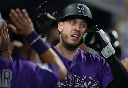Jul 21, 2023; Miami, Florida, USA;  Colorado Rockies first baseman C.J. Cron (25) is congratulated after hitting a two-run home run in the first inning against the Miami Marlins at loanDepot Park. Mandatory Credit: Jim Rassol-USA TODAY Sports