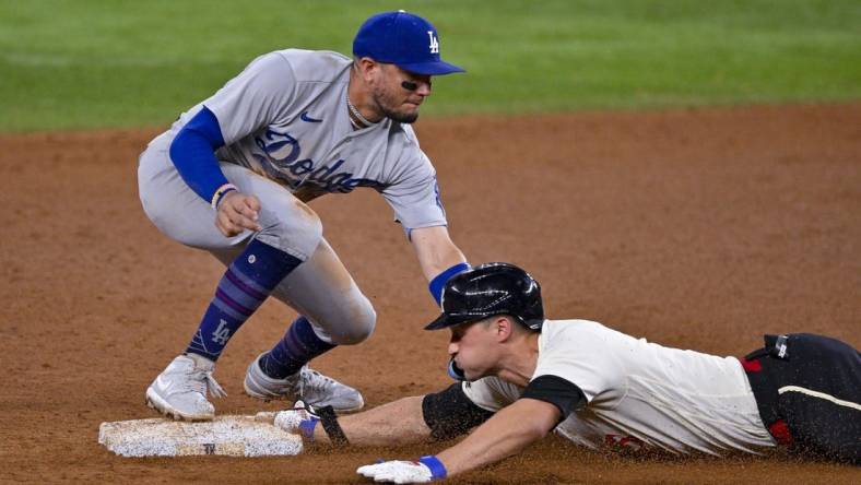 Jul 21, 2023; Arlington, Texas, USA; Texas Rangers shortstop Corey Seager (5) slides under the throw to Los Angeles Dodgers shortstop Miguel Rojas (11) at second base during the eighth inning at Globe Life Field. Mandatory Credit: Jerome Miron-USA TODAY Sports