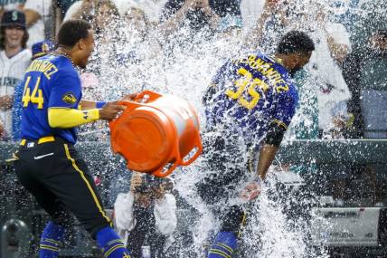 Jul 21, 2023; Seattle, Washington, USA; Seattle Mariners designated hitter Teoscar Hernandez (35) receives a water-bucket dunking from center fielder Julio Rodriguez (44) after hitting a walk-off RBI-single against the Toronto Blue Jays during the ninth inning at T-Mobile Park. Mandatory Credit: Joe Nicholson-USA TODAY Sports