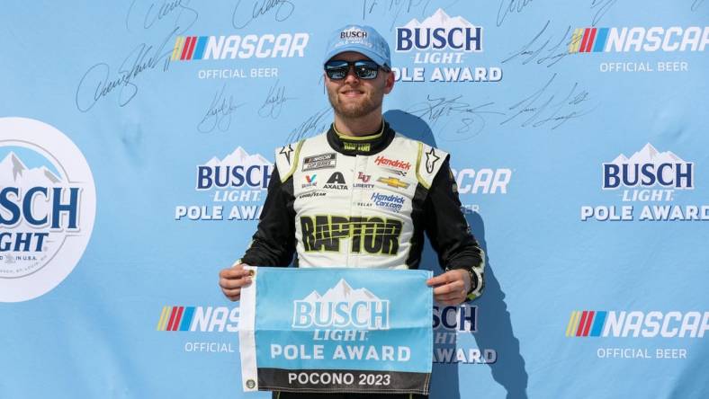 Jul 22, 2023; Long Pond, Pennsylvania, USA; NASCAR Cup Series driver William Byron stands with the Busch Light Pole Award after winning the pole for the HighPoint.com 400 at Pocono Raceway. Mandatory Credit: Matthew O'Haren-USA TODAY Sports