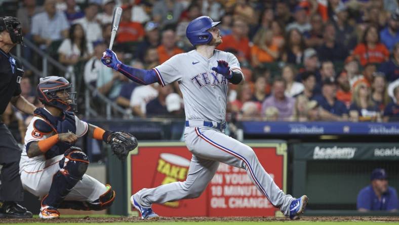 Jul 25, 2023; Houston, Texas, USA; Texas Rangers catcher Jonah Heim (28) hits a single during the fifth inning against the Houston Astros at Minute Maid Park. Mandatory Credit: Troy Taormina-USA TODAY Sports